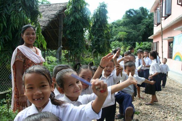 Children with a teacher at the school entrance